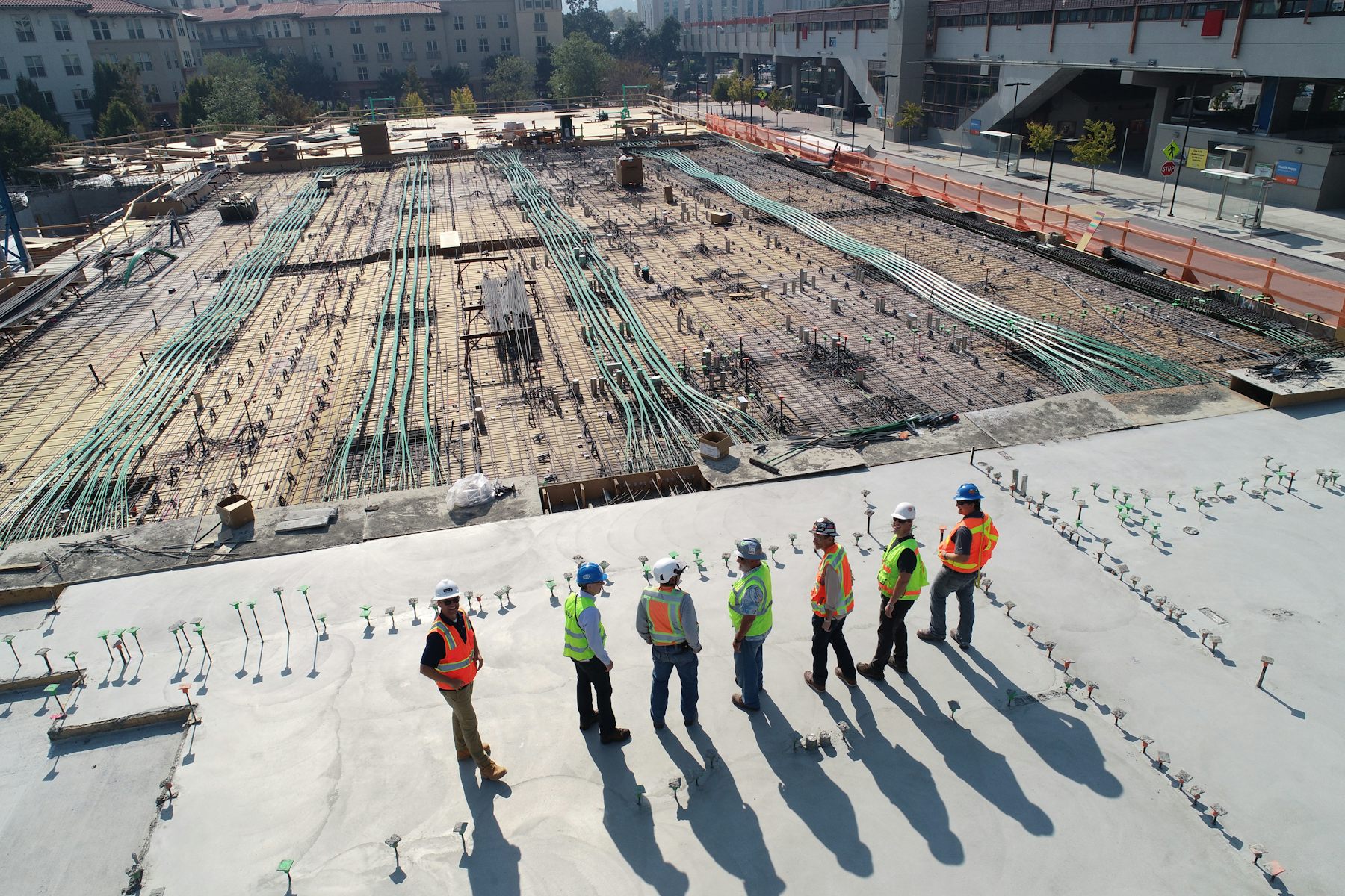 Commercial construction crew reviewing work on a large commercial building deck